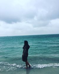 Full length of woman on beach against sky