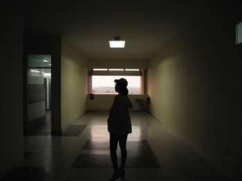 Rear view of woman walking in corridor of building