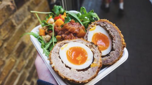 Cropped hand holding meal in plate