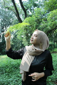 Smiling young woman standing on field