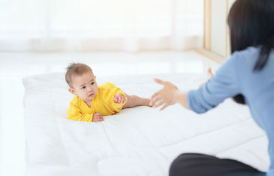 Happy baby go on caepet at home. child and parenthood concept, mother playing with little baby