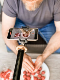 Midsection of man using mobile phone