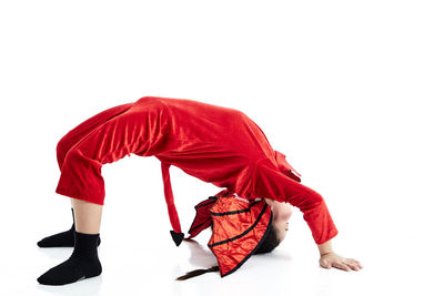 Side view of woman with red umbrella against white background