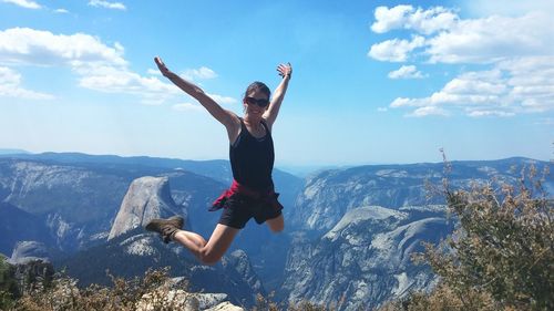Young woman jumping on rock
