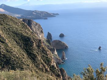 High angle view of rocks by sea against sky