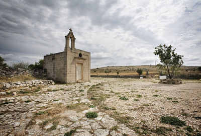 Old building on field against sky