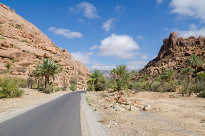 Road amidst rock formation against sky