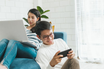 Young man using mobile phone while sitting in office