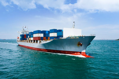 Angle view in front container ship full speed in green sea, business and industry 