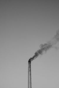 Smoke emitting from chimney against sky