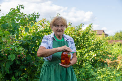Portrait of senior woman holding pickle jar