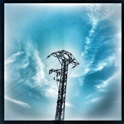 Low angle view of electricity pylon against cloudy sky