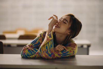 Portrait of young woman sitting on table