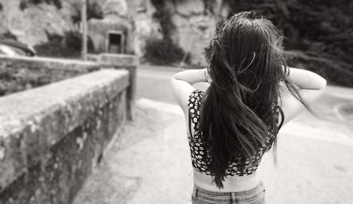 Rear view of woman standing against built structure