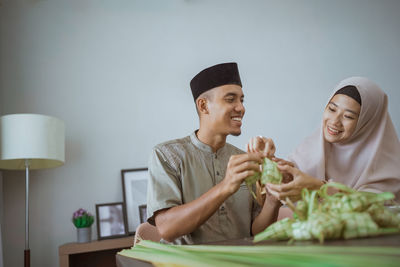 Portrait of smiling young woman holding food at home