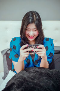 Portrait of smiling young woman using mobile phone