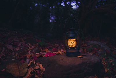 Close-up of illuminated lantern on rock