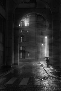 Man walking on illuminated street at night