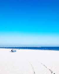 Scenic view of beach against clear blue sky