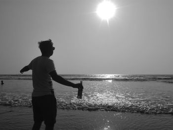 Man standing at beach against sky