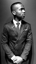 Portrait of young man standing against wall