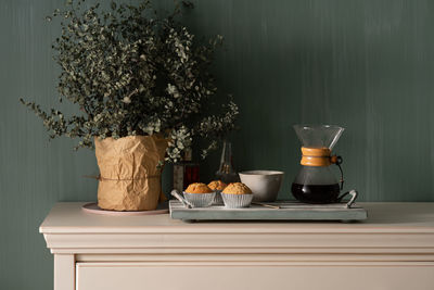 View of coffee and potted plant on table