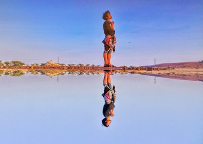 Full length of woman against blue sky