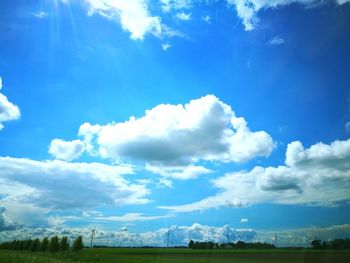 Low angle view of field against blue sky