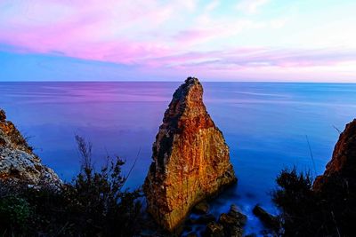 Panoramic view of rock formation in sea against sky