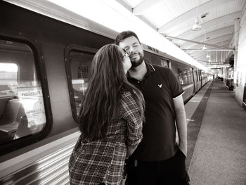 Portrait of young woman standing in train