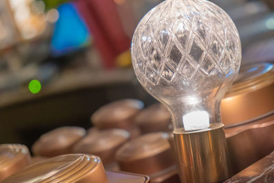 Close-up of light bulb hanging on table