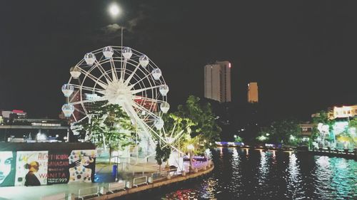 Illuminated ferris wheel at night