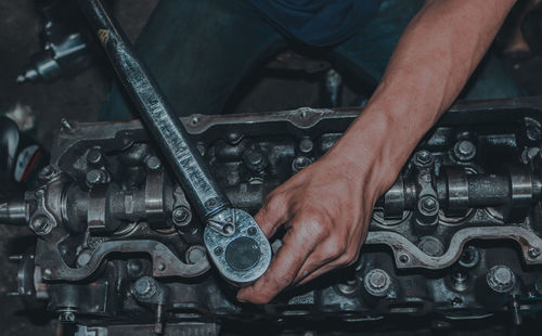 The mechanic is checking the engine.