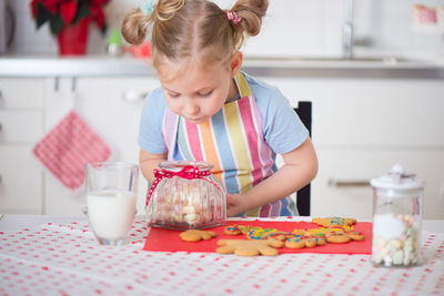 Close-up of cute girl sitting at kitchen