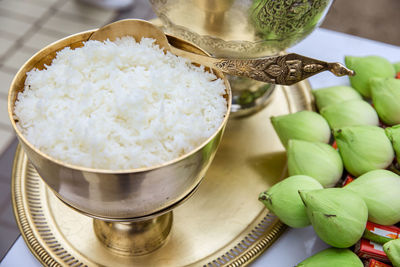 Rice in gold bowl and green lotus prepare for give alms food to buddhist monk