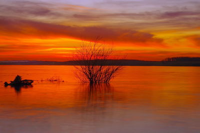 Scenic view of lake against orange sky