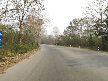 Road amidst trees against clear sky