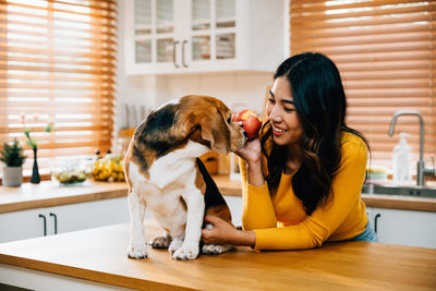 Portrait of young woman with dog at home