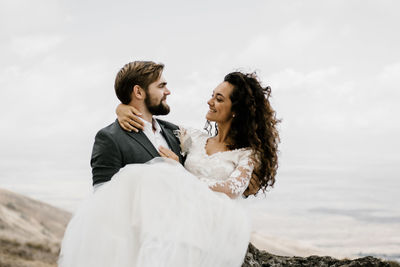 Young couple kissing against sea