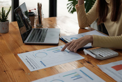 Midsection of business colleague working at office