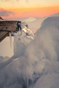 Scenic view of frozen mountain against sky during sunset