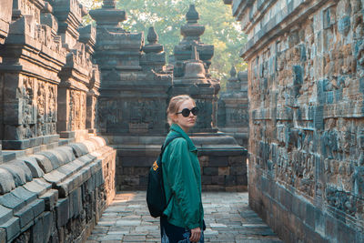 Full length of man wearing sunglasses standing against building