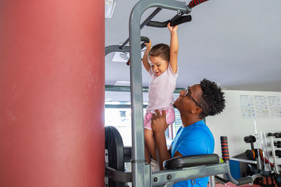 Dad teaching daughter to do pull ups