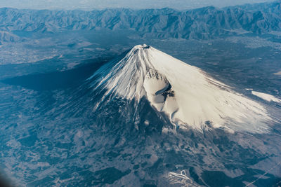 High angle view of woman on snowcapped mountain by sea