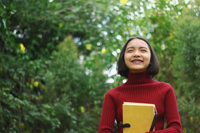 Close-up of girl holding book outdoors