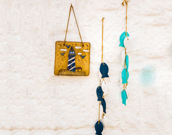 Close-up of clothespins hanging on clothesline against wall