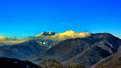 Scenic view of mountains against cloudy sky