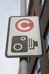 Close-up of road sign against sky