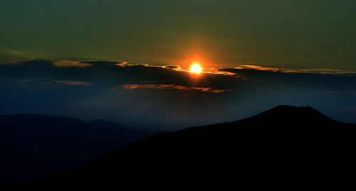 Scenic view of silhouette mountains against sky during sunset