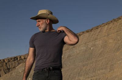 Adult man in cowboy on desert against mountain. almeria, spain